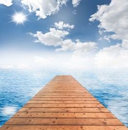 Muelle de madera hacia el infinito con mar y cielo